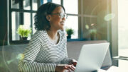 smiling woman with a laptop in a business setting