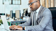 business man using a laptop in an office setting