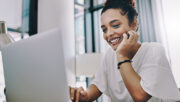 smiling woman using using a laptop in an office setting