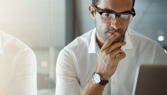 pondering man using a laptop in an business setting